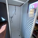 Image de la douche du bateau de couleur blanche.