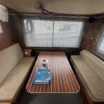 Pénichette Locaboat 935 Kerplouf (1986) – Salon mit Tisch und umbaubaren Sitzbänken