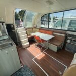 Flusskreuzer Nicols 1100 Lodève (1998) – Salon mit Tisch, Sitzbank und Küchenzeile